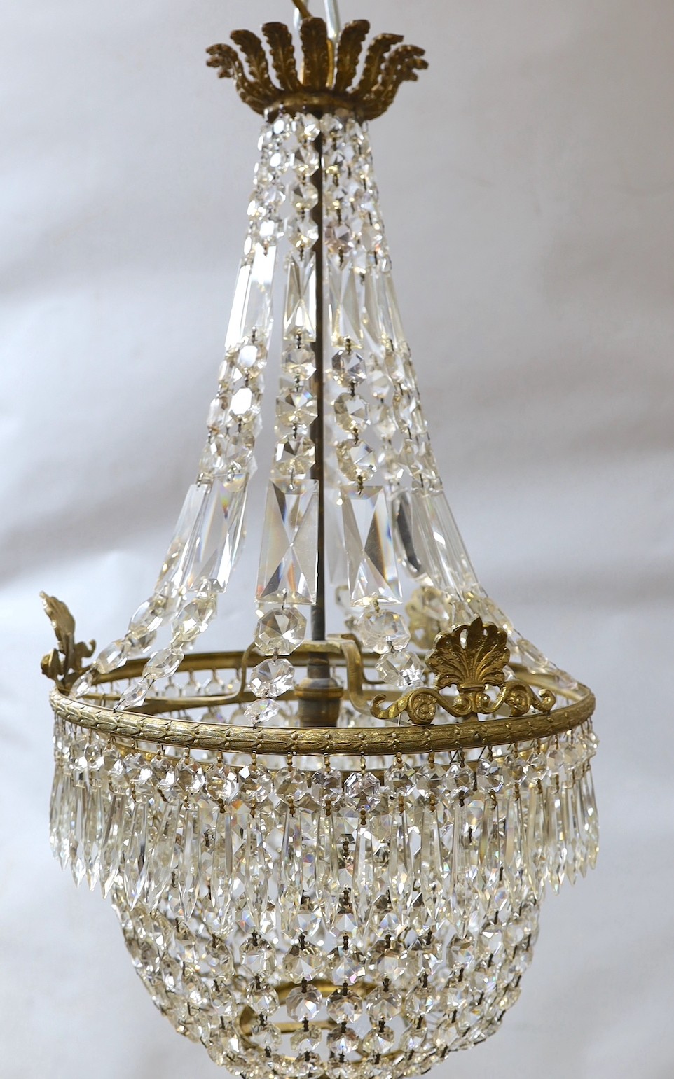 A brass bag shaped ceiling light hung faceted bead and spear drops, height approximately 80 cms.